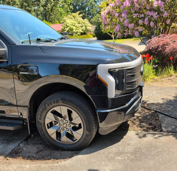 truck parked on a concrete driveway partially in a hole that needs more gravel